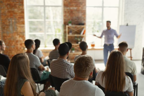 A man hosting a training course in front of a group of people