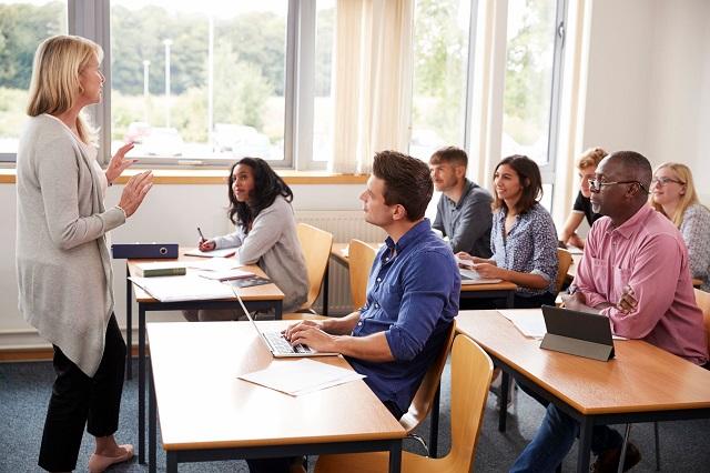 Adults seated in a classroom with the tutor standing at the front.